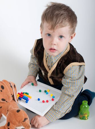 a little boy playing with mosaics in the studioの写真素材