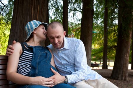 pregnant woman with husband in the parkの写真素材