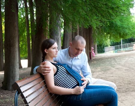 pregnant woman with husband in the parkの写真素材