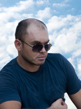man in sunglasses on the blue sky backgroundの写真素材