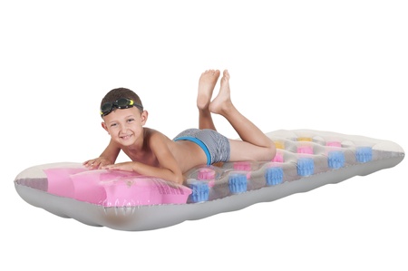 boy lying on an inflatable mattress on a white backgroundの写真素材