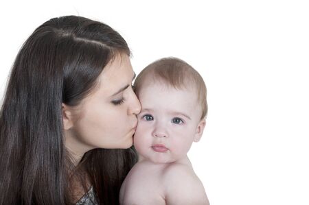 mother kissing her child isolated on white backgroundの写真素材