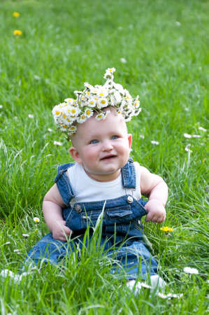 happy child in a flower wreath outdoorsの写真素材