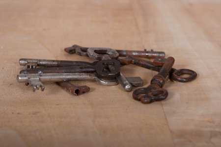 Old rusty keys on a wooden background