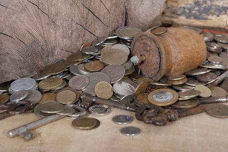 Pile of old coins, keys and a rusty coffee makerの写真素材
