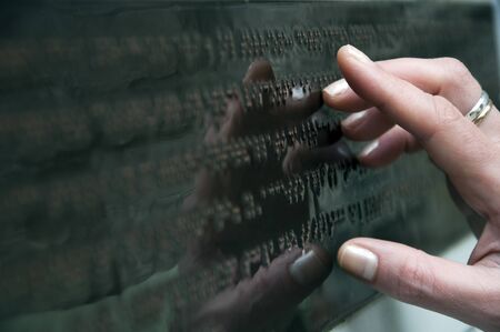 female hand touches braille text, blind readingの写真素材