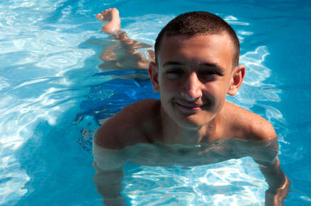 teenager swims in the pool enjoying a vacationの写真素材