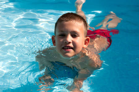 boy swims in the pool enjoying a vacationの写真素材
