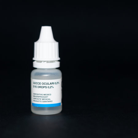eye drops in a small transparent bottle on a black backgroundの写真素材