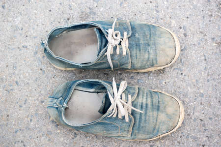 pair of old jean sneakers on grungy backgroundの写真素材