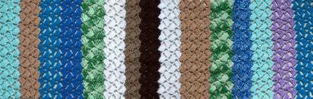 Knitted rug with a pattern of stripes. Simples of wool texture pattern as background.