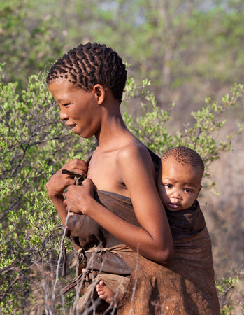 Kalahari Desert, Botswana-October 16, 2011  Young Bushman woman with child in natural their life environment on October 16, 2011 in Kalahari Desert of Botswana のeditorial素材