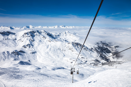 View from top of the mountain to clouds on the horizon and the funicular at French Alps in Meribel.の写真素材
