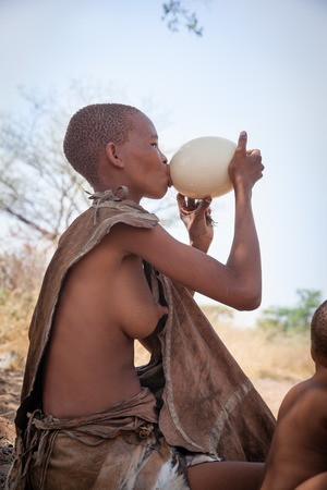 Kalahari Botswana October 16 2011. Young Bushmen woman drinks a water from ostrich egg which keeps in it to stay cold on October 16 2011 in Kalahari desert of Botswana.のeditorial素材