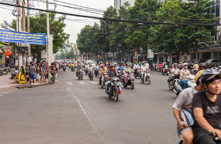 Ho Chi Minh, Vietnam-December 9, 2013. Crowd of people ride motorcycle in rush hour and streets are crowded with scooters, motorbikes and bicycles on December 9, 2013 in Ho Chi Minh City.のeditorial素材