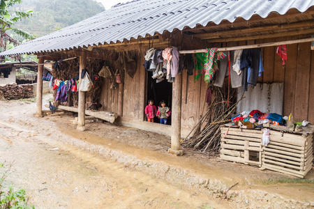Lao Cai, Vietnam-December 15, 2013. Unidentified Hmong ethnic minority little girls are looking through doors from their home on December 15, 2013 at one of Lao Cai province villages.のeditorial素材