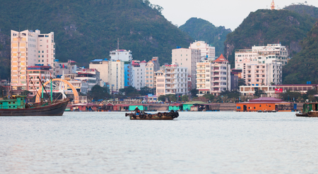 Cat Ba, Vietnam-December 19, 2013. Cat ba island city view with Vietnamese style buildings, hotels by the seaside and restaurants on the water at sunset on December 19, 2013 at fishing harbour pier in Ha Long Bay of North Vietnam.のeditorial素材