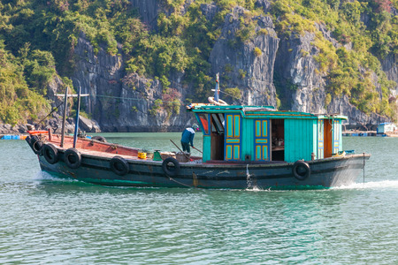 Ha Long Bay, Vietnam-December 20, 2013. Vietnamese woman is sorting catch of fish on the boat at little settlement of fishermen on December 20, 2013 in Ha Long Bay in north Vietnam.のeditorial素材