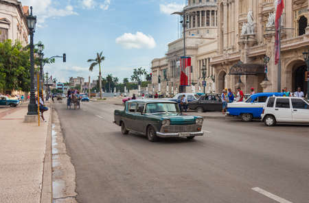 Havana, Cuba-October 07, 2016. Common and popular for tourist, busy street with classic, old style, American cars and people next to the historical, famous Great Theatre at old part of Havana City.のeditorial素材