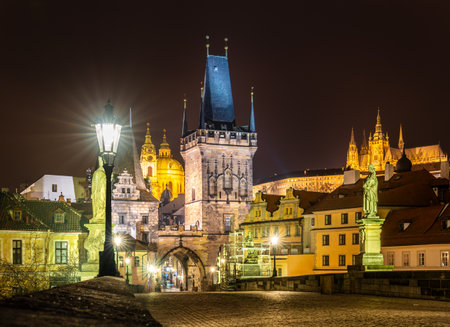 Prague, Czech Republic-January 31, 2019. Night view of the famous, historical Charles Bridge over the Vltava river, The Lesser Town Bridge Tower and Prague Castle on the hill in old Prague town.のeditorial素材