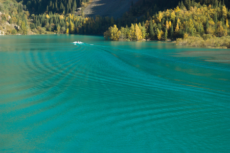 Small motor boat on the calm water. Autumn reflection.の写真素材