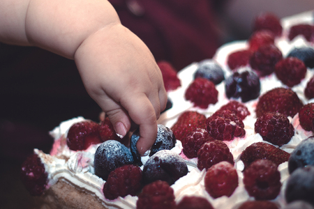 baby hand smashes first birthday berry cakeの写真素材