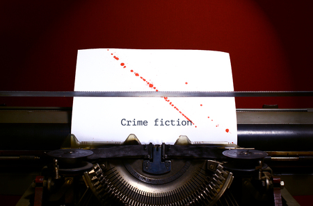 Typewriter spelling crime fiction on paper with blood splashesの写真素材