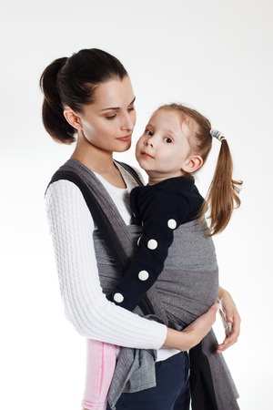 A toddler girl in front cross carry wrap in woven baby carrierの写真素材