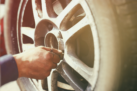 A man tightens the nuts on the car wheelの写真素材
