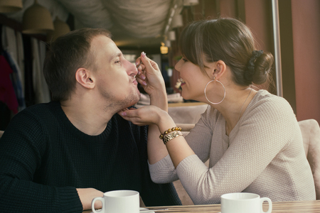 An asian young woman and caucasian man mixed couple. Woman is feedind her boyfriend by dessertの写真素材