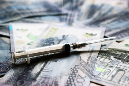 Syringe close-up veiw on tenge banknotes background with motion blur effectの写真素材