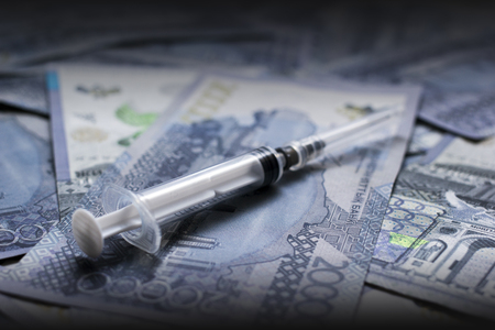 Syringe close-up veiw on tenge banknotes backgroundの写真素材
