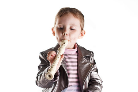 Portrait of a toddler girl playing on fluteの写真素材