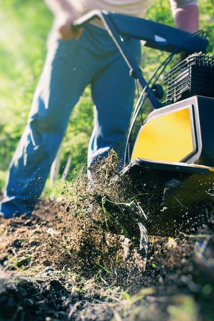 A close up view on motor cultivator during plow process spring season garden works conceptの写真素材