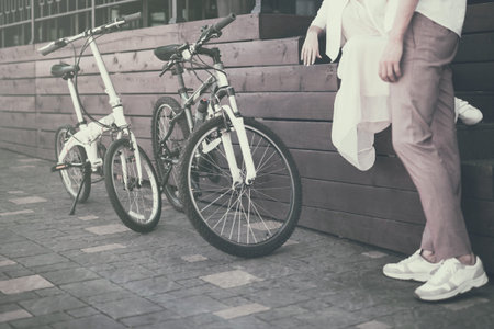 View on man legs standing beside two bicycles on a sidewalk