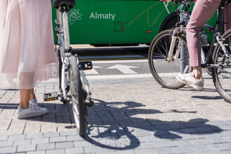 Woman legs standing near bicycle and man legs on bike in front of cross road