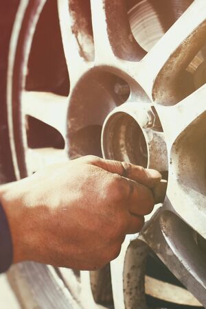 A man hand during wheel nut tightening process close up viewの写真素材