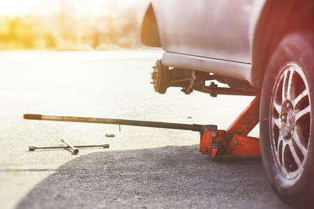 A hydraulic floor jack and wheel wrench ready for wheel repairの写真素材