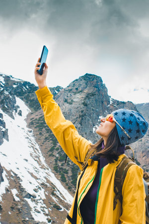Searching for mobile connection in wild nature on vacation. Perfect day outdoor. Woman with smartphone. Rock mountain landscape. Woman making mobile photo. No communication on holiday concept imageの写真素材