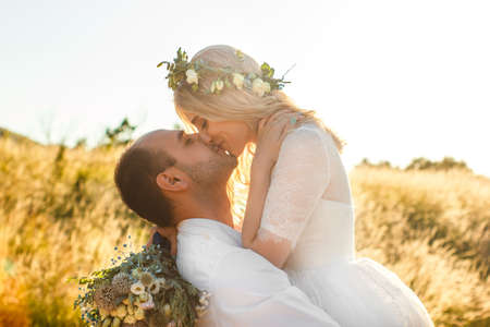 Back view on bride and groom holding hands in sunny summer day. Outdoor wedding and relationsheep romantic concept. Selective soft focus.の写真素材