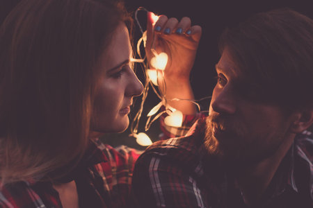 Evening romantic date. Caucasian couple in shirts, attractive woman and beard man lookin each other,...