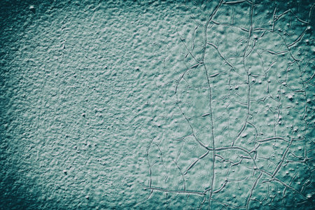 Surface of the old metal wall is covered with a lot of cracks, in which a rusty metal base is...