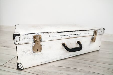 Used old vintage white suitcase on the floor.の写真素材