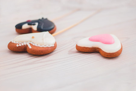 The concept of St. Valentines Day and Wedding on white wooden background and heart shaped ginger...