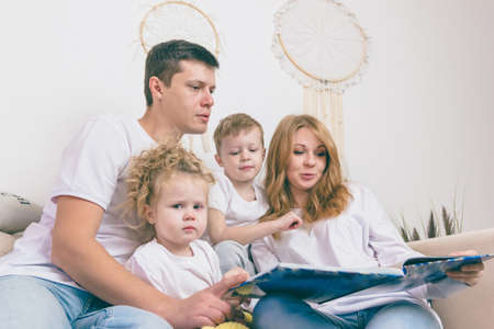 Young parents reads with their children. Happy family conceptの写真素材