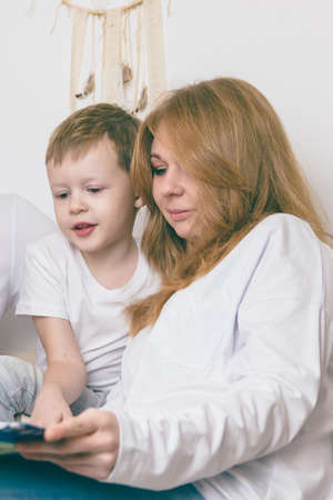 A loving mother reads with her child. Happy family conceptの写真素材