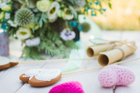 Close up view on two rolled paper sheets with wedding vowes, heart shaped cookies bisquites and bride bouquet decor.の写真素材