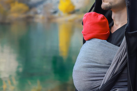 Man is carrying her child and travel in autumn mountain lake.