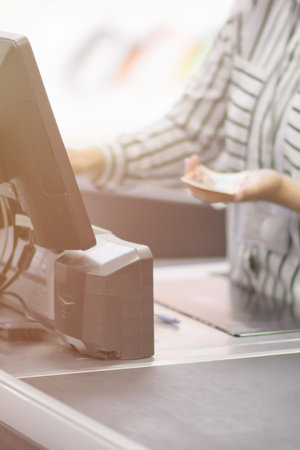 Close up of a hand cashier cashier behind the cash register monitorの写真素材
