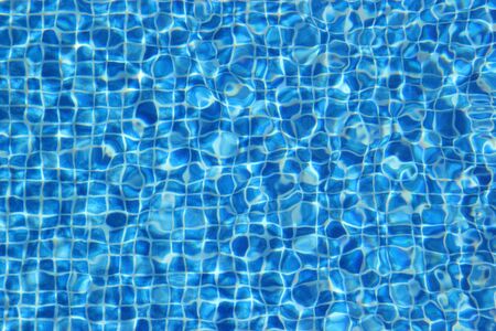 Top view of clear water in a blue tile pool background. Ripple effectの写真素材